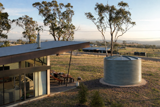 Large 24,000L tank beside modern house with rural aspect.
